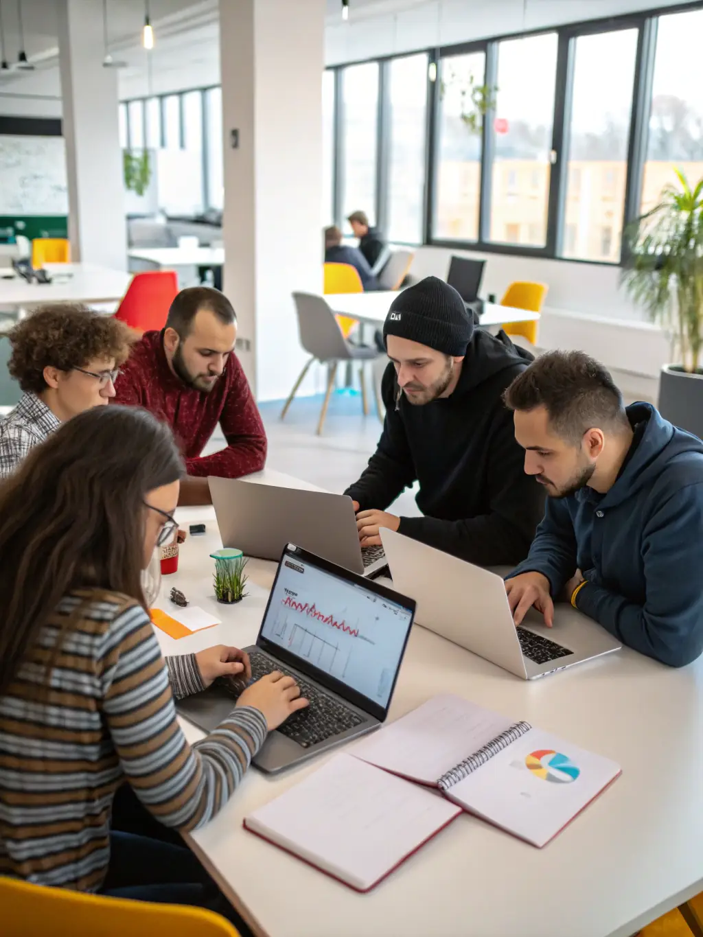 A diverse team of web developers collaborating in a modern office space, brainstorming ideas and working on different aspects of a website project, representing Neural Web's collaborative approach.
